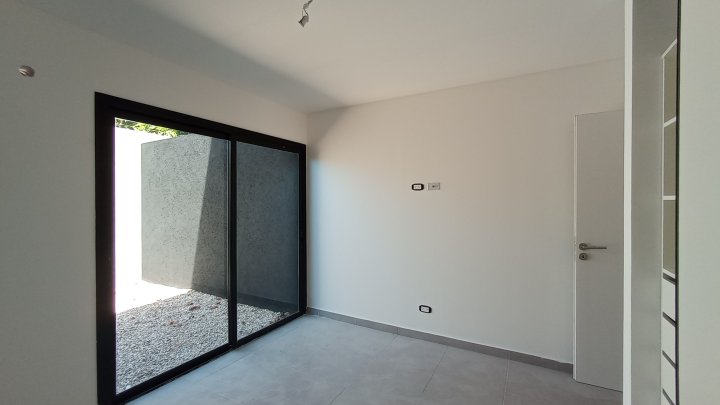 Dormitorio con ventanal de piso a techo