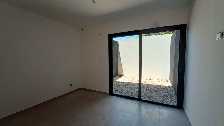 Dormitorio con ventanal corredizo hacia el patio